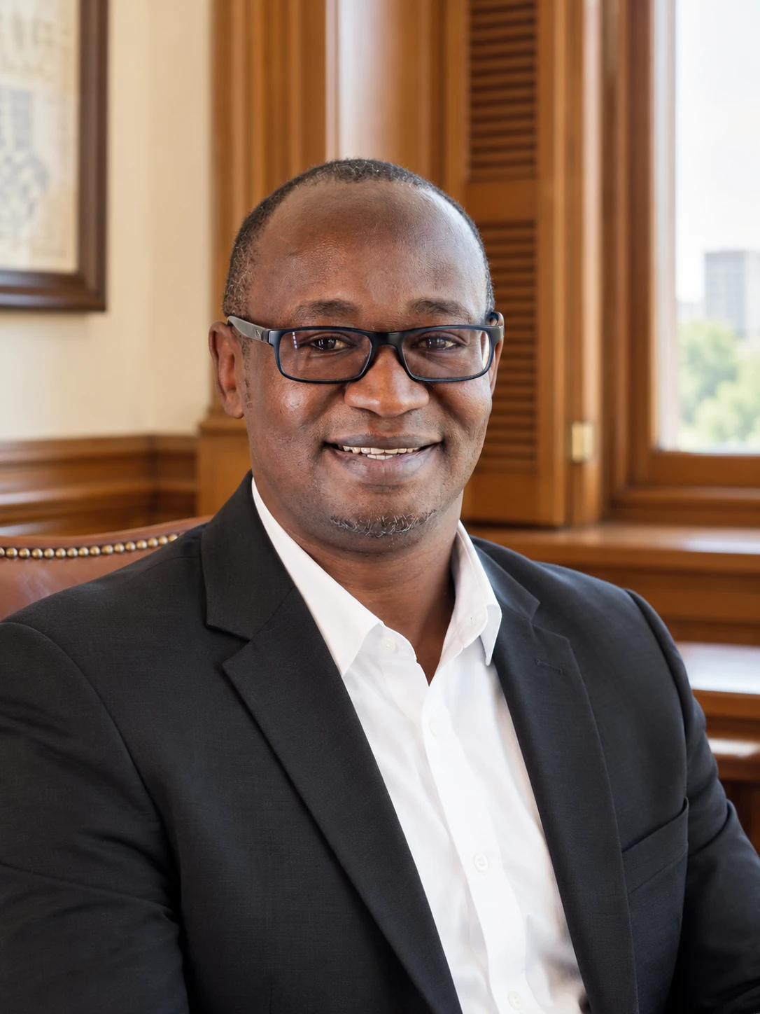 A smiling man wearing glasses in a Capitol office