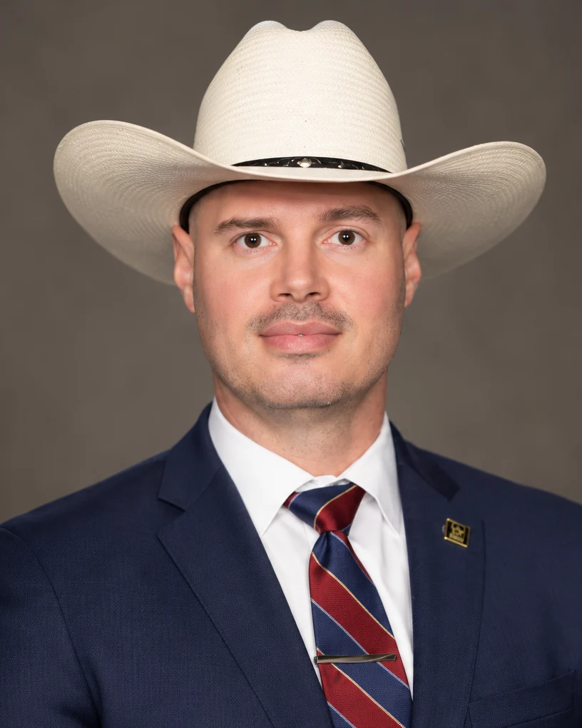 A distinctive portrait of a man in a cowboy hat and navy suit