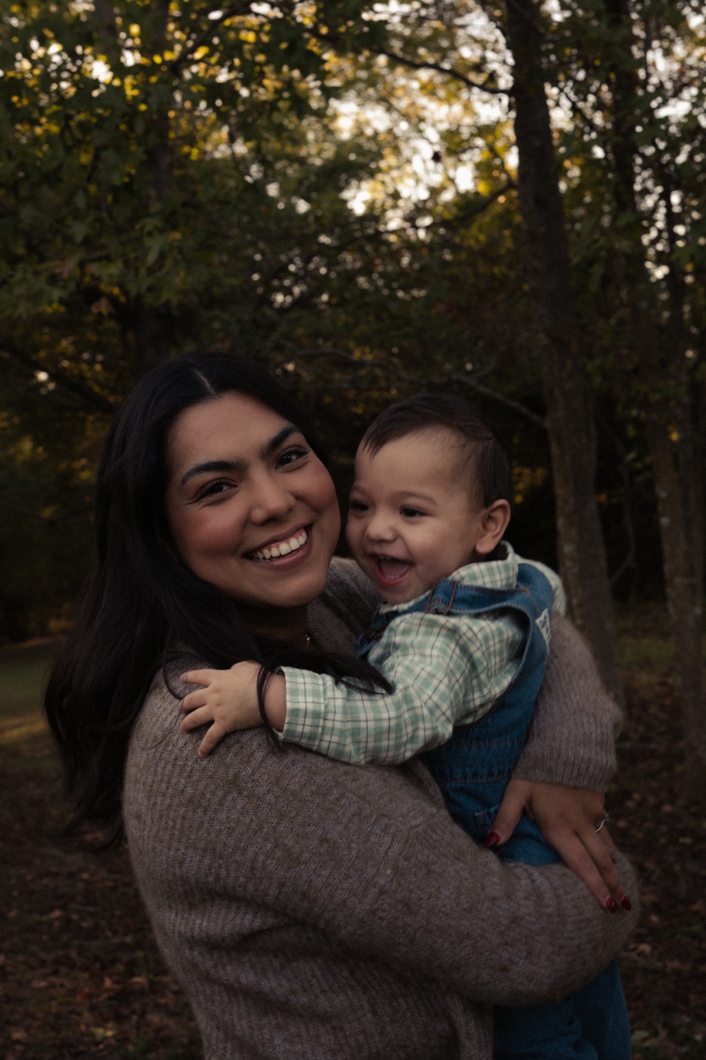 A mother and her laughing child in soft evening light